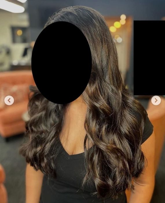 A reviewer showcasing their shiny hair after applying the conditioner.