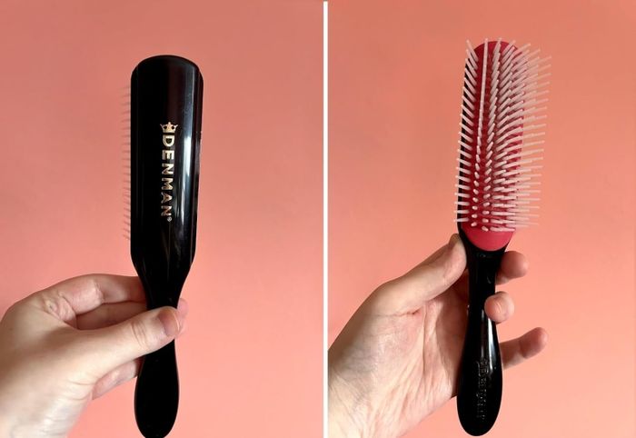 A hand gripping a Denman hairbrush