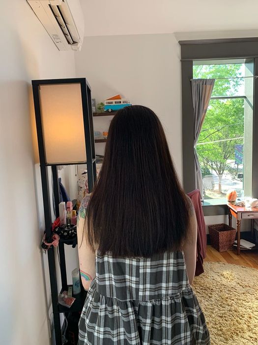 A reviewer showing off their hair after using the CreaClip tool for a DIY haircut, with neat and even ends.