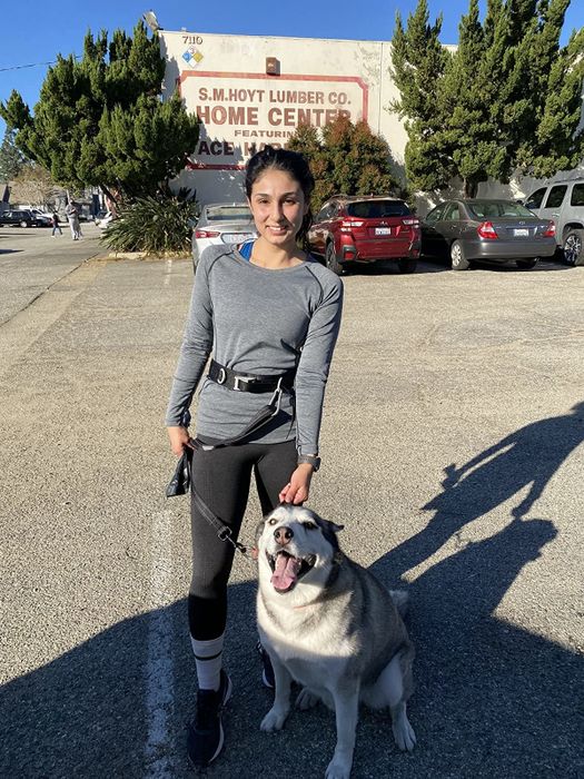 A reviewer is seen wearing a long-sleeved scoop-neck shirt in gray.