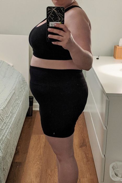 A reviewer shares a mirror selfie wearing a sports bra and the biker shorts.