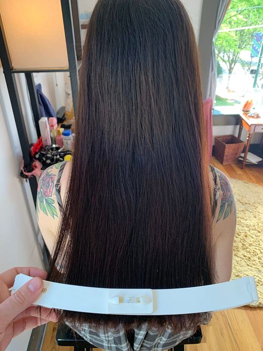 A reviewer using the CreaClip to align the ends of their hair for an even cut.