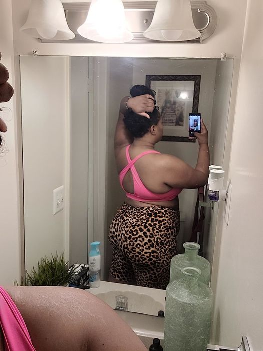 A reviewer modeling cheetah print shorts paired with a pink top