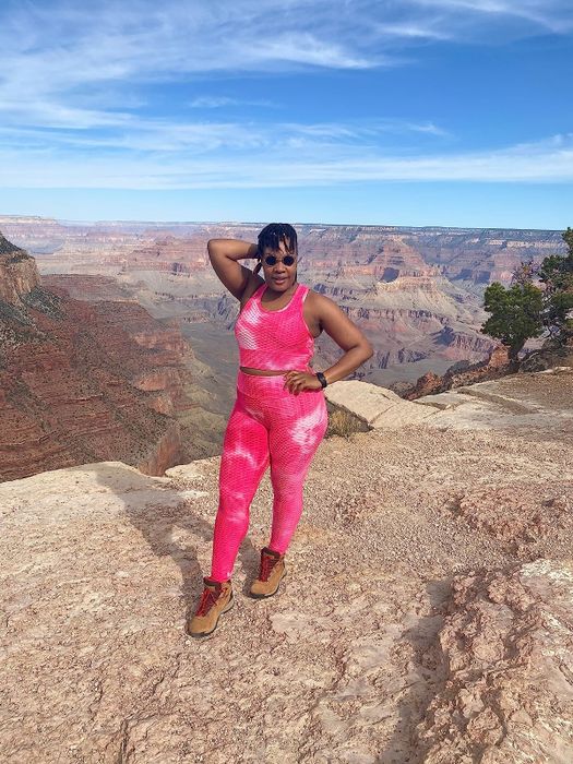 a reviewer modeling a pink matching set paired with brown hiking boots