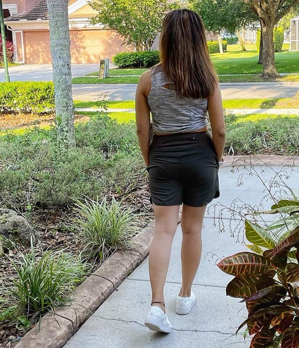 a reviewer wearing black shorts paired with white shoes and a grey top