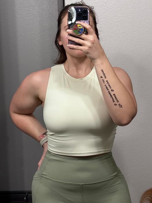 A reviewer modeling a white top paired with green bottoms