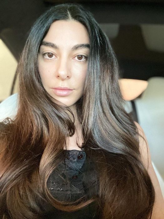 same reviewer with a glossy, blown-out hairstyle