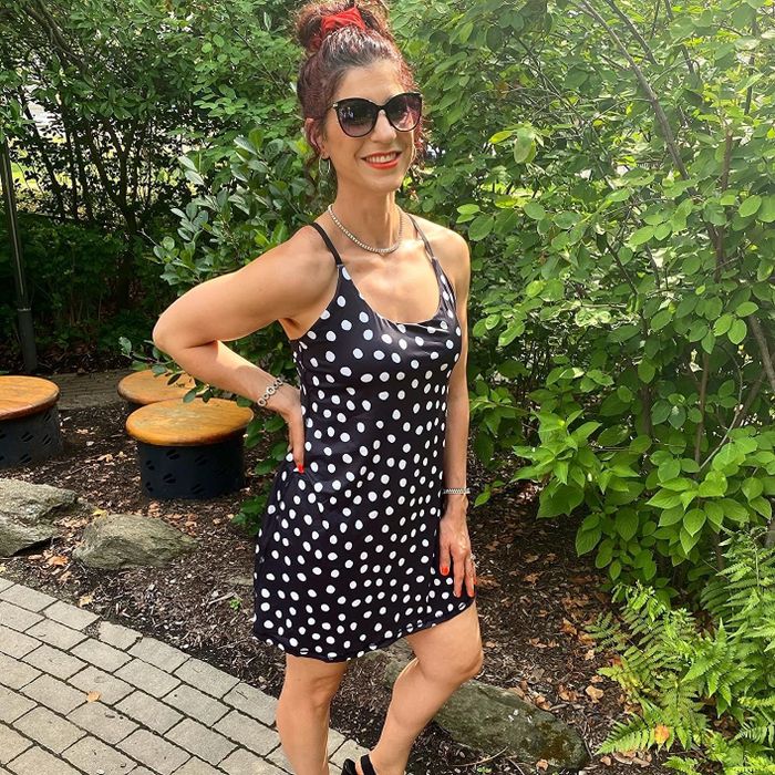 A reviewer modeling a black and white polka-dot dress