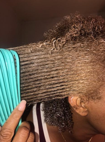 The reviewer is using the brush to detangle their hair.