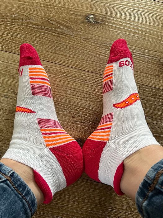 a reviewer modeling white, red, and orange socks