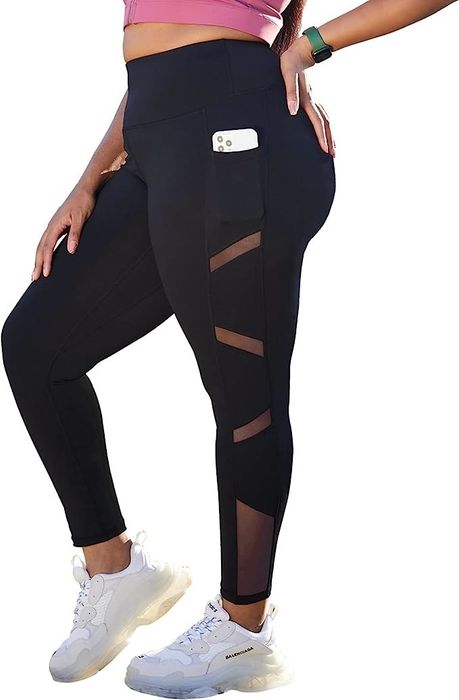 A model wearing leggings paired with white sneakers and a pink top