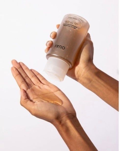 Hands pouring Ouai shampoo into an open palm