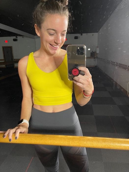 a reviewer modeling a yellow top paired with black bottoms