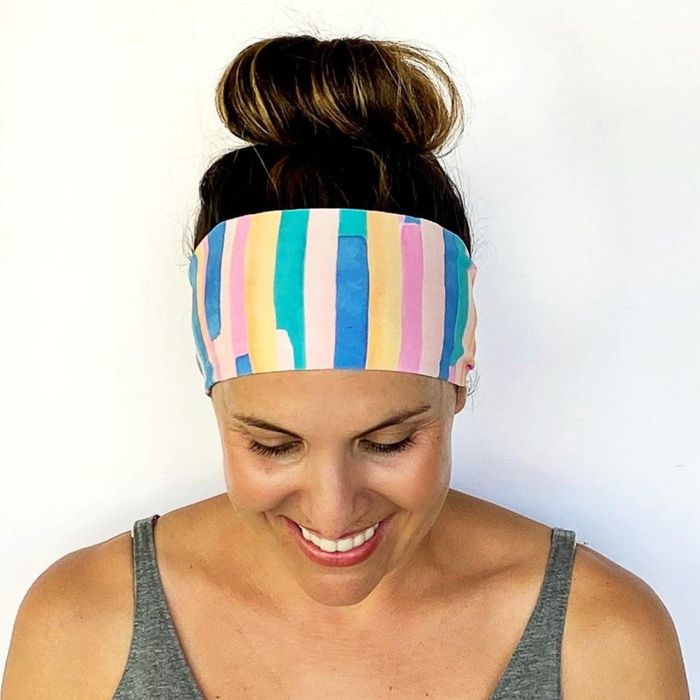 A model is seen wearing a pastel striped version of the headband.
