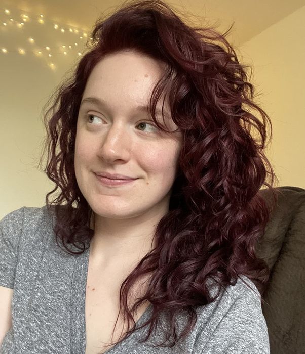 A reviewer with bouncy, defined curls after using the hair oil