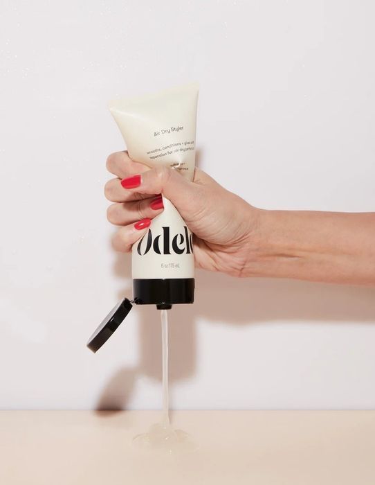 a model dispensing the cream into their palm