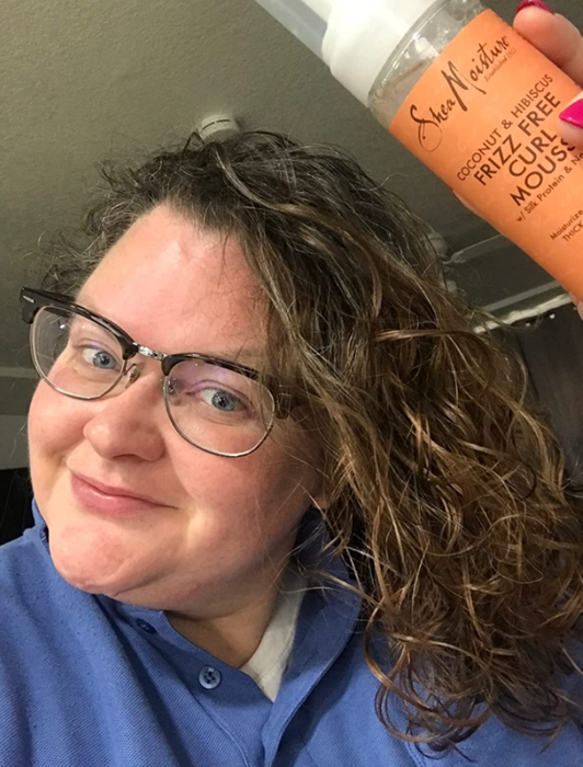 reviewer showcasing beautifully defined curls thanks to the mousse