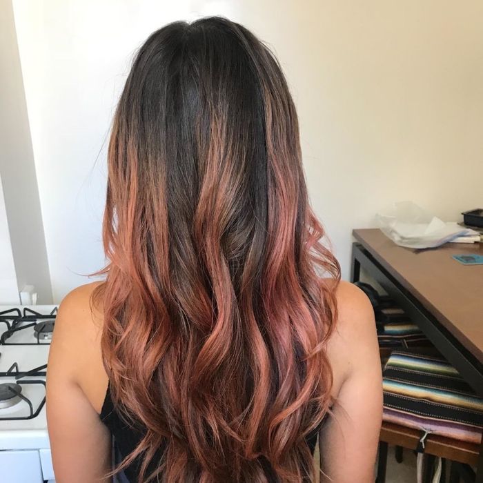 Photo of a reviewer’s brown hair with striking red highlights after using the product