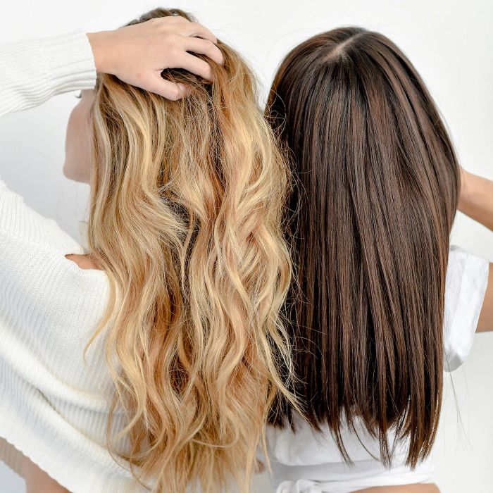 two models styling their hair by running their fingers through it