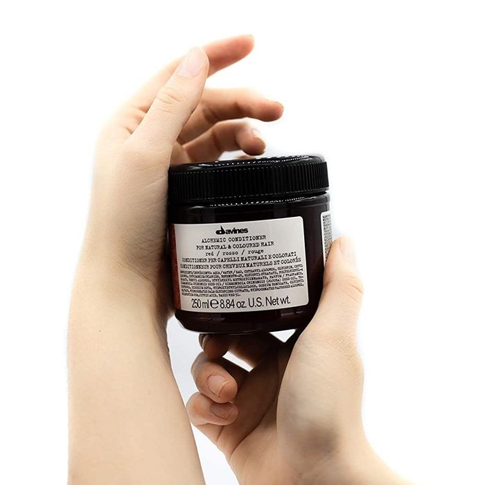 A model holding a jar of the product in their hands