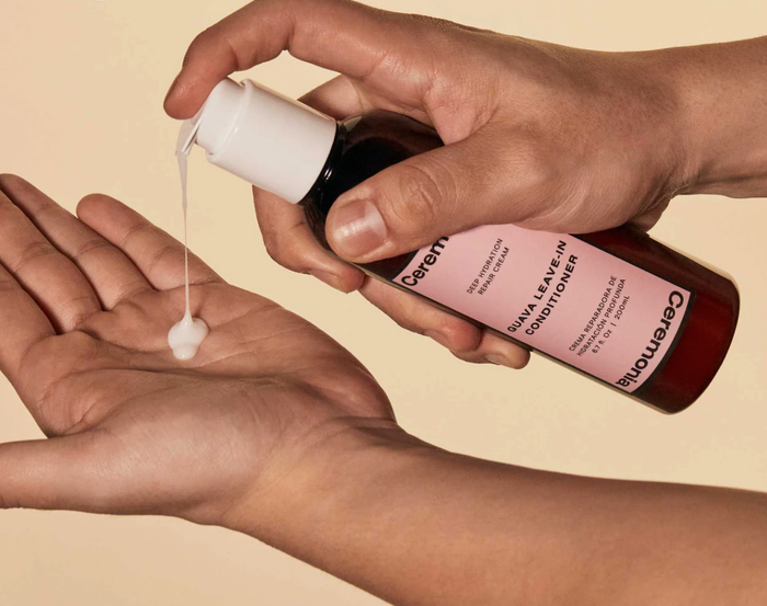 a model dispensing the creamy leave-in conditioner into their hand