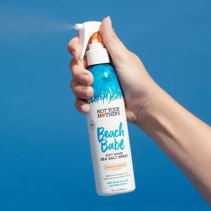 a model holding the bottle of salt spray