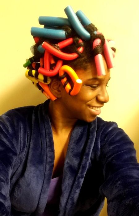 A reviewer with the curling rods styled in their hair