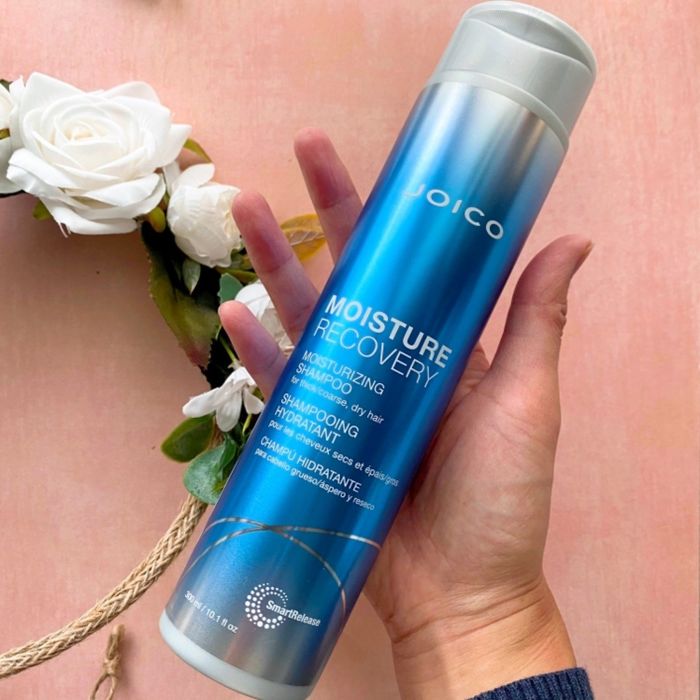 reviewer holding the shampoo bottle