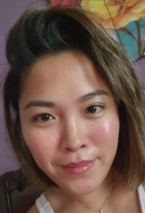 A reviewer showcasing glowing skin after using the serum