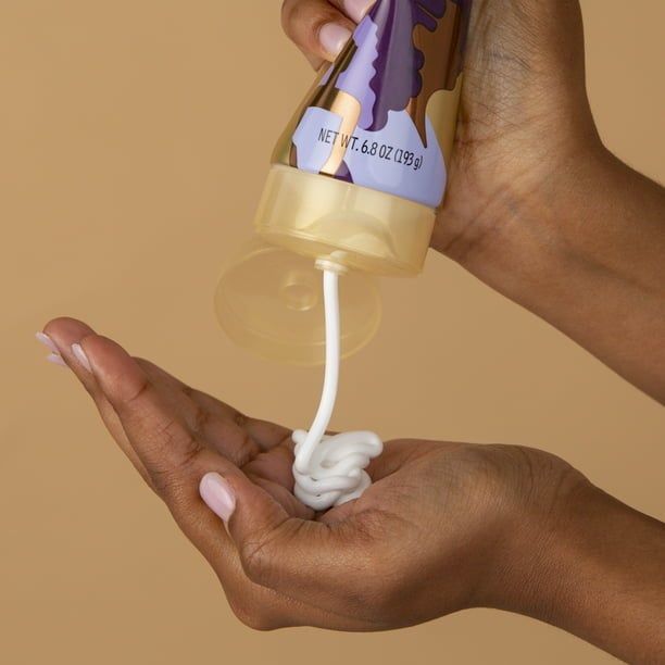 Someone dispensing hair cream into their hand