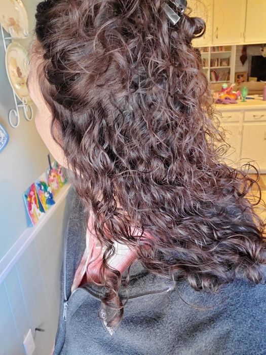 A photo of the reviewer from behind, showcasing their curls after applying the heat and humidity gel