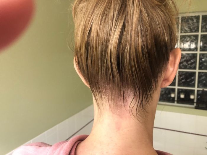 after photo of the same reviewer showcasing all flyaways and baby hairs neatly smoothed, with the bun appearing more polished and sleek after product application