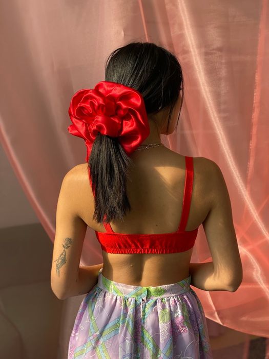 A photo of the back of a model wearing the red oversized scrunchie