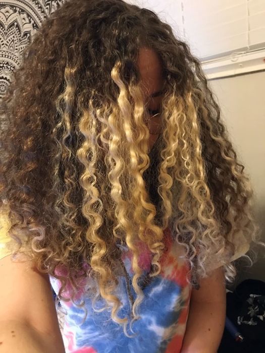 An after photo of the same reviewer’s hair looking hydrated with more defined curls