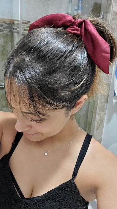 a red ribbon tied around the reviewer's ponytail