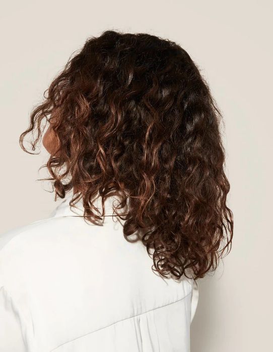 a model showcasing their curly hair