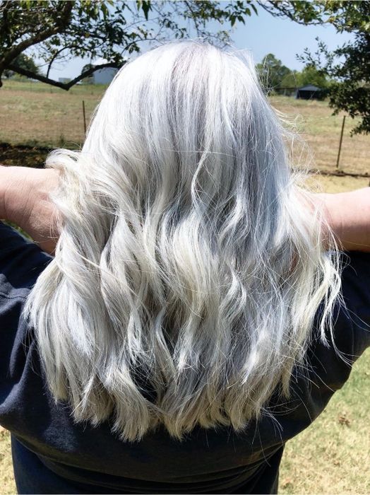 A reviewer showcasing their healthy, gray hair after using the heat protectant