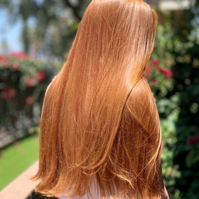 Reviewer flaunting long, sleek, and glossy red hair