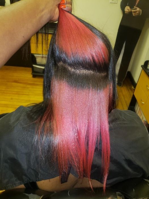 Reviewer with straightened natural hair showcasing the striking red hue on their black hair
