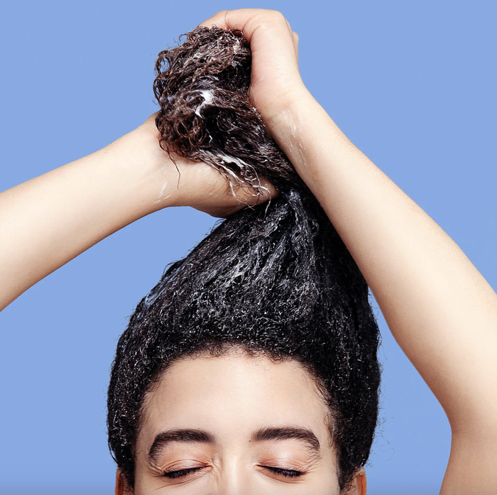 a model applying the hydrating hair mask