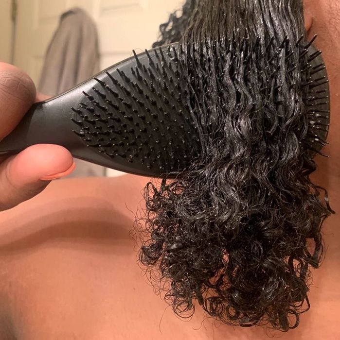 A reviewer using the brush on their wet 4B type hair