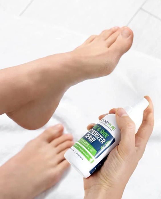 a model demonstrating the spray being applied to their foot