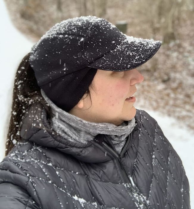 A reviewer wearing the black cap in the snow