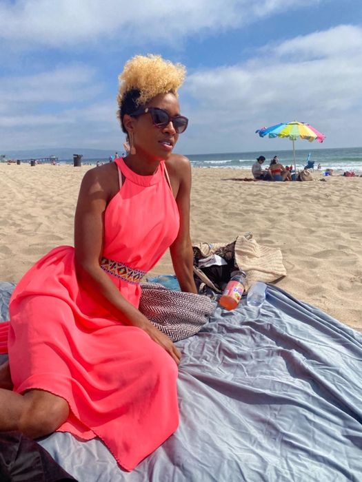 A reviewer with natural hair using the spray to keep their style intact even at the beach