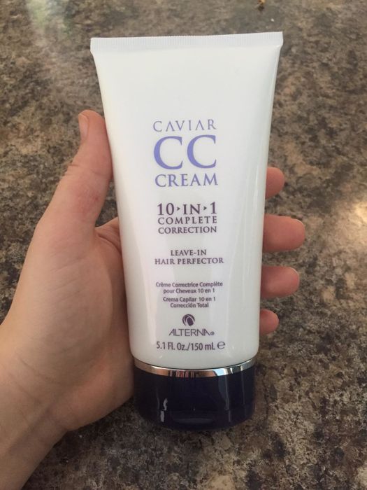 Reviewer holding the leave-in hair cream.