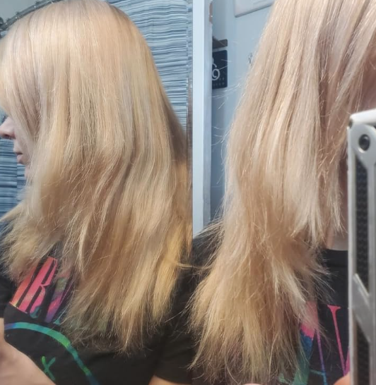 A person with long, straight hair is seen from behind, wearing a black top