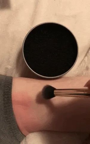 A gif shows an eyeshadow brush leaving pigment on an arm, then being cleaned in the sponge for a few seconds, followed by the brush being wiped on the arm with no makeup left.