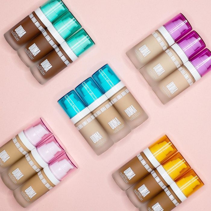 15 bottles of the foundation in various shades, each with differently colored caps