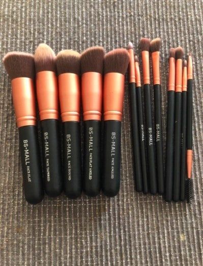 A complete set of makeup brushes neatly arranged on a rug