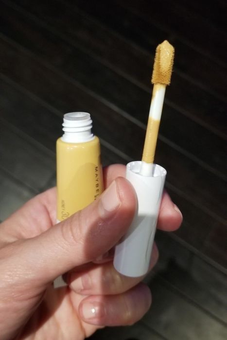 A reviewer holding the concealer tube